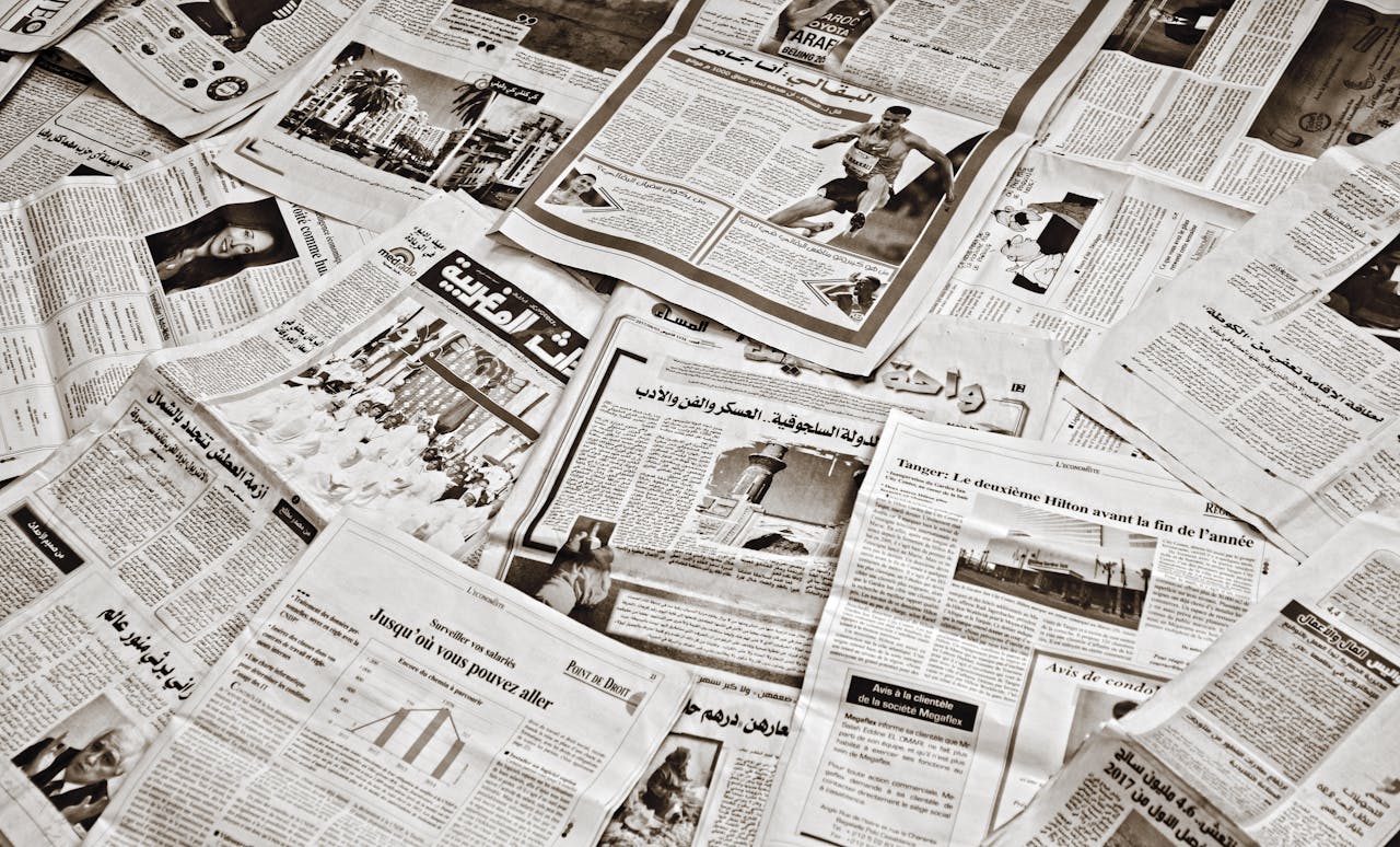 A collection of Arabic newspapers spread across a surface, showcasing diverse headlines and articles.